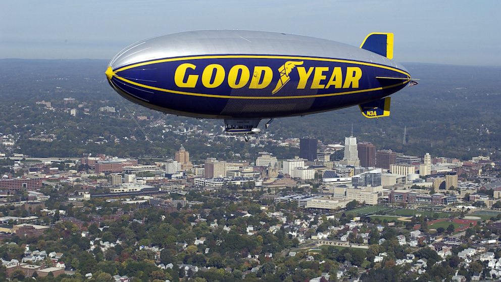 The Goodyear Blimp Stars and Stripes flying over the Akron skyline.