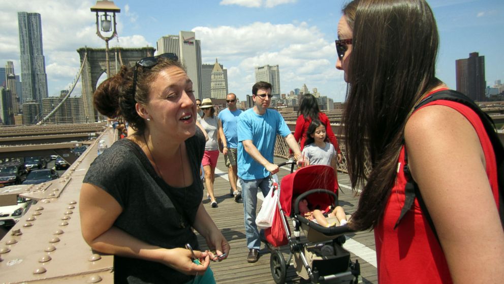 PHOTO: Olivia Fader, left, and Mal Harris, both of Halifax, Nova Scotia, get engaged on the Brooklyn Bridge.