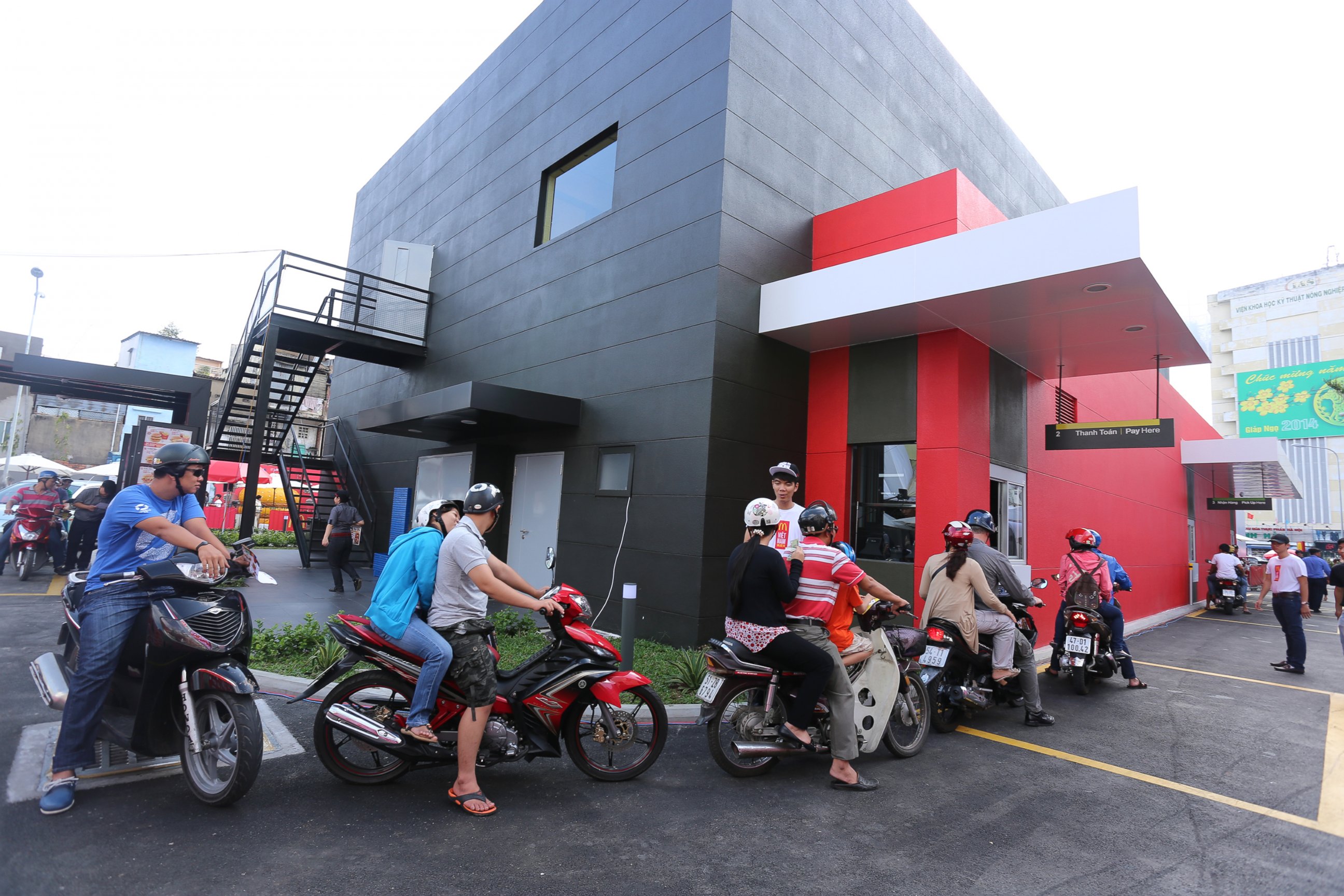 PHOTO: McDonald's customers on scooters experiencing the first drive-thru restaurant in Vietnam