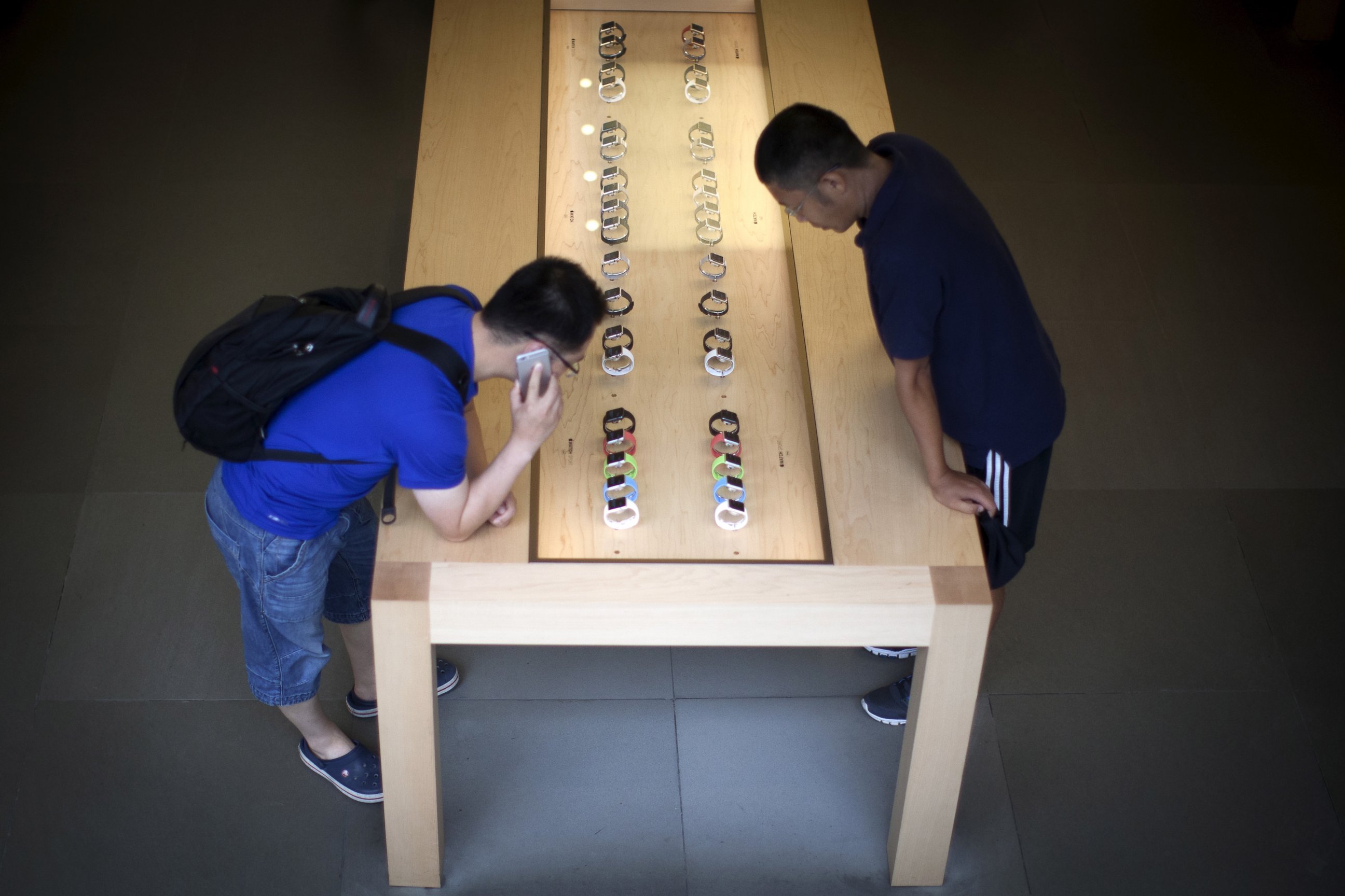 PHOTO: Customers look at Apple watches inside the Apple store in New York, July 21, 2015. 