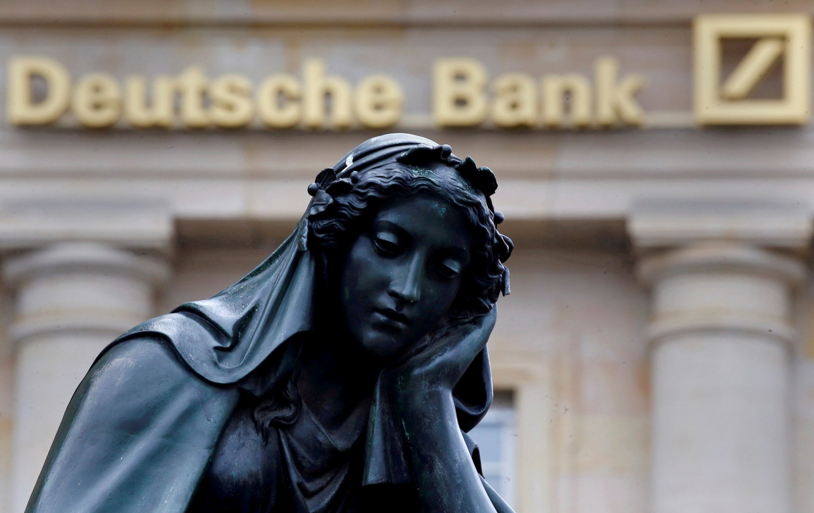 PHOTO: A statue is seen next to the logo of Germany's Deutsche Bank in Frankfurt, Germany, Jan. 26, 2016. 