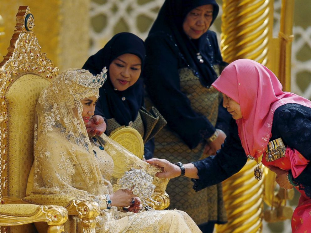 PHOTO: Women adjust the veil of Dayangku Raabi'atul 'Adawiyyah Pengiran Haji Bolkiah as she waits for Prince Abdul Malik to arrive for the enthronement ceremony at their wedding in the Nurul Iman Palace in Bandar Seri Begawan April 12, 2015.