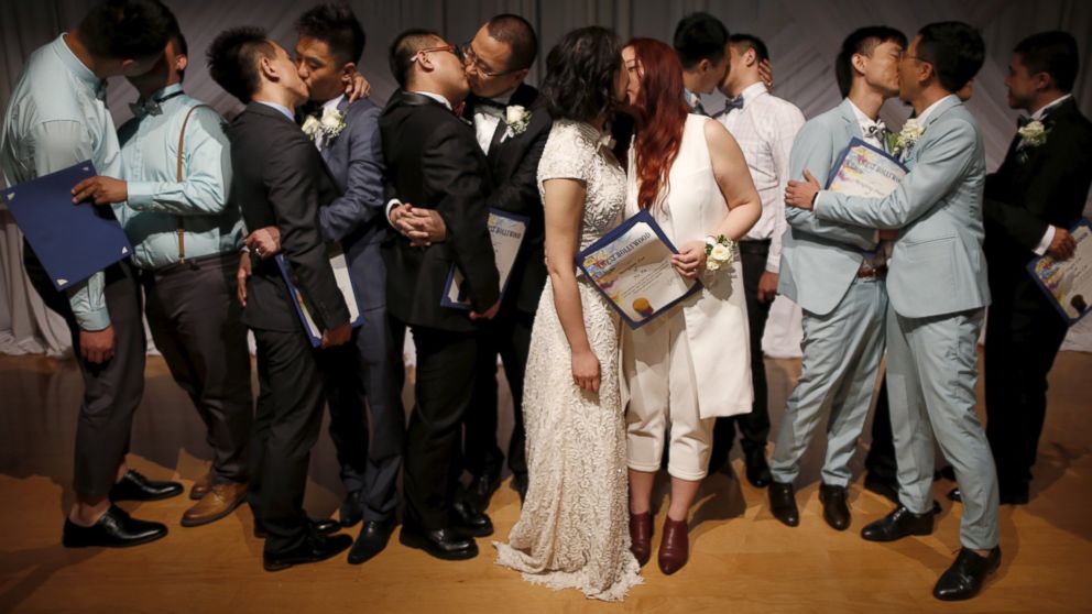 Couples kiss after getting married at a group wedding for seven same-sex couples from China, in West Hollywood, Calif. on June 9, 2015. 