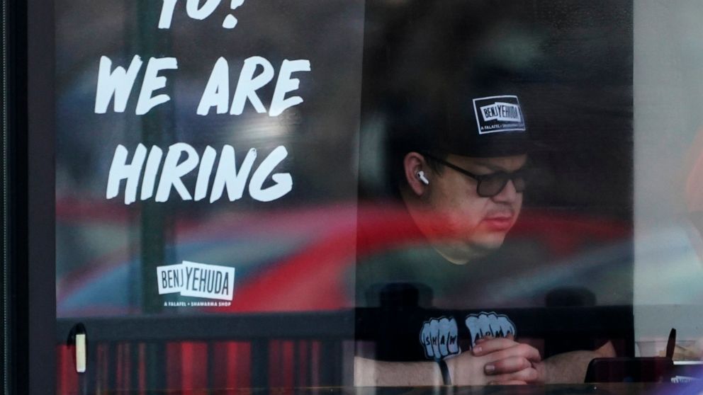 A hiring sign is displayed at a restaurant in Schaumburg, Ill., Friday, April 1, 2022. More Americans applied for unemployment benefits last week, and while layoffs remain low, it's the fifth straight week claims have topped the 230,000 mark. Applica