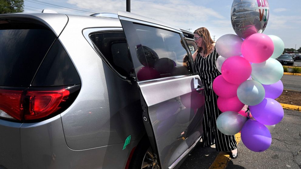 In this Tuesday, July 16, 2019, Melanie Matcheson loads balloons into her Chrysler Pacifica in Southington, Conn. For Melanie Matcheson, no vehicle other than a minivan could efficiently haul her family of two adults and five children ages 2 to 22. (