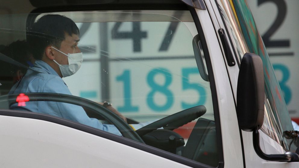 A car stops in front of an electronic stock board of a securities firm in Tokyo, Wednesday, March 31, 2021. Asian shares were mixed Wednesday as data showed a strong economic recovery in China but worries lingered about the coronavirus pandemic. (AP 