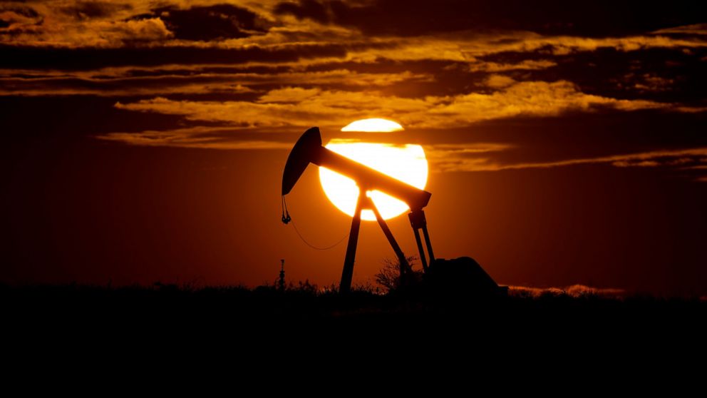 FILE - The sun sets behind an idle pump jack near Karnes City, USA, April 8, 2020. Oil prices surged another $5 per barrel on Wednesday, March 2, 2022, after an agreement by the United States and other major governments to release supplies from strat