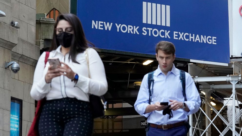 People pass an entrance of the New York Stock Exchange, Wednesday, June 16, 2021. Stocks are off to a mixed start on Wall Street Wednesday as traders wait for the latest decision on interest rates from the Federal Reserve. (AP Photo/Richard Drew)