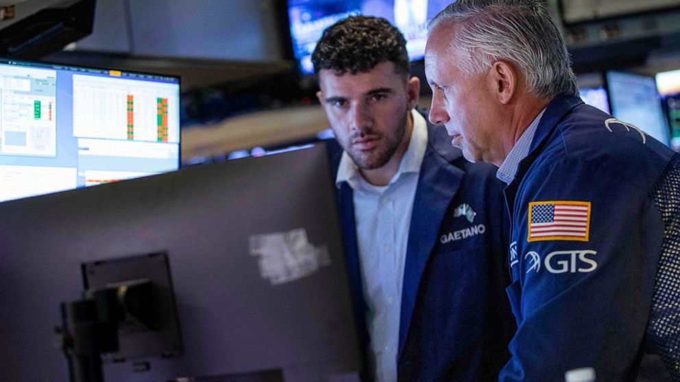 In this photo provided by the New York Stock Exchange, specialist Donald Himpele Jr., right, works with a colleague at his post on the trading floor, Wednesday, June 8, 2022. Stocks edged lower in afternoon trading on Wall Street Wednesday and tradin