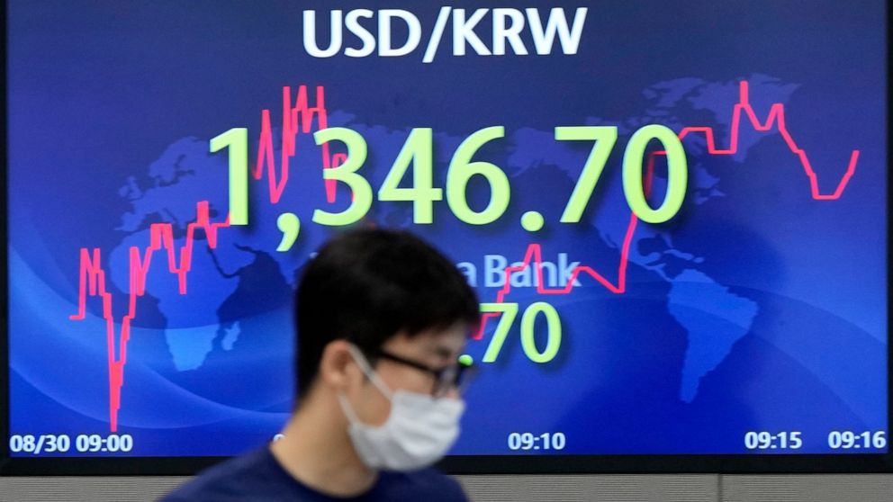 A currency traders walks by the screen showing the foreign exchange rate between U.S. dollar and South Korean won at a foreign exchange dealing room in Seoul, South Korea, Tuesday, Aug. 30, 2022. Asian stocks were mixed Tuesday after Wall Street fell