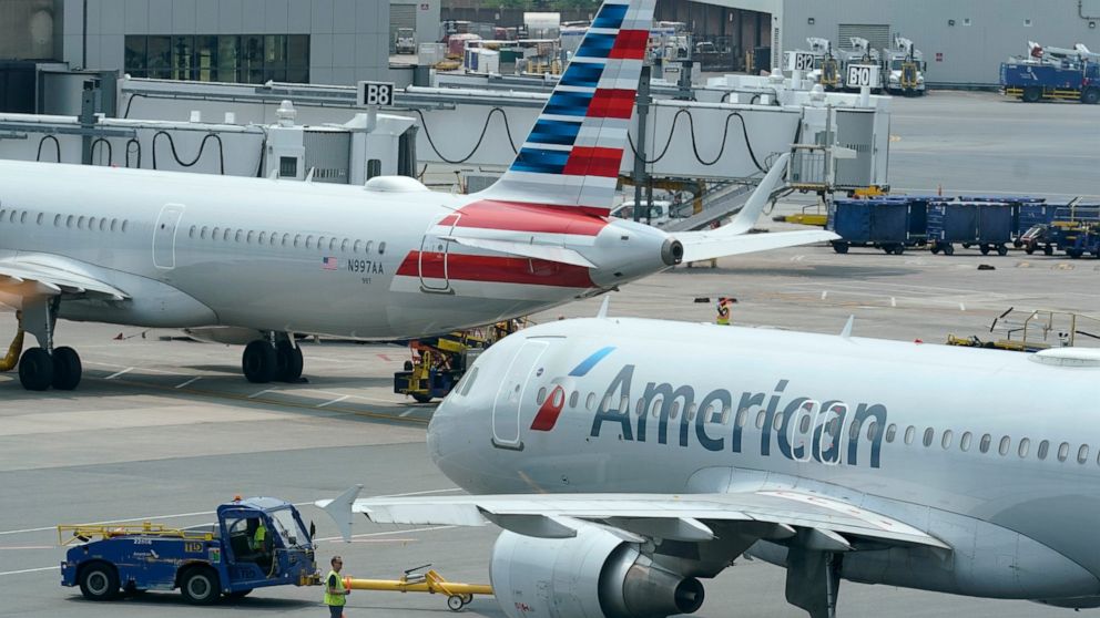 FILE -American Airlines passenger jets prepare for departure, Wednesday, July 21, 2021, near a terminal at Boston Logan International Airport, in Boston. Airlines facing a pilot shortage are boosting pay. The CEO of American Airlines said Thursday, J