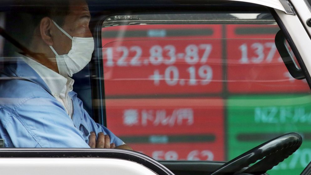 A driver waits in front of an electronic stock board of a securities firm in Tokyo, Tuesday, June 11, 2019. Asian shares are mostly higher as investor jitters over trade eased after U.S. President Donald Trump suspended plans to impose tariffs on Mex