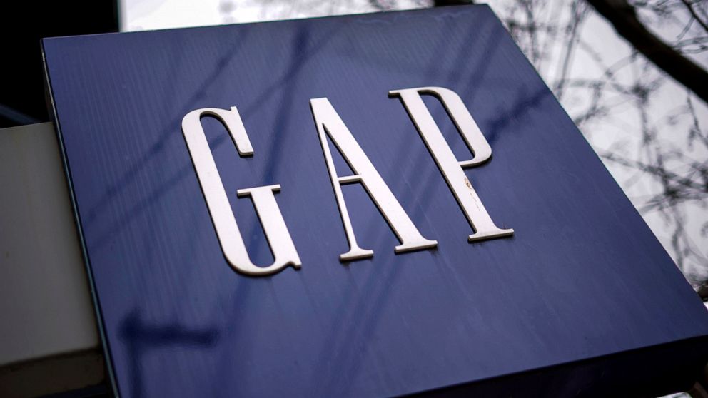 FILE - A sign for the GAP is seen on a storefront in Pittsburgh on Wednesday, Jan. 12, 2022. Gap is slashing 500 corporate jobs in San Francisco and New York as it looks to reduce expenses amid languishing sales, a company spokesperson confirmed on T