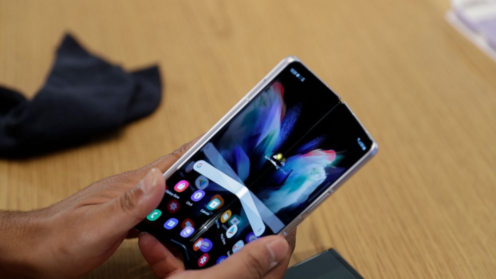 A person demonstrates folding the Samsung Galaxy Fold 3 on Monday, Aug. 9, 2021 at Samsung KX in London. Samsung is hoping cheaper but more durable versions of its foldable phones will broaden the appeal of a high-concept design that’s so far fizzled