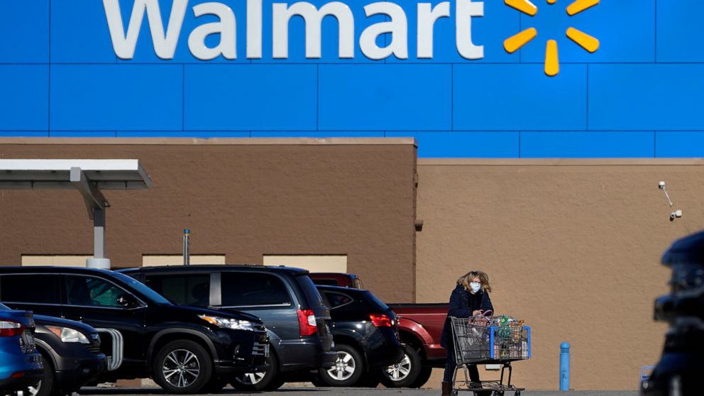 FILE - A woman wheels a cart with her purchases out of a Walmart, on Nov. 18, 2020, in Derry, N.H. Walmart Inc. on Tuesday, Aug. 16, 2022, reported fiscal second-quarter net income of $5.15 billion. The Bentonville, Arkansas-based company said it had