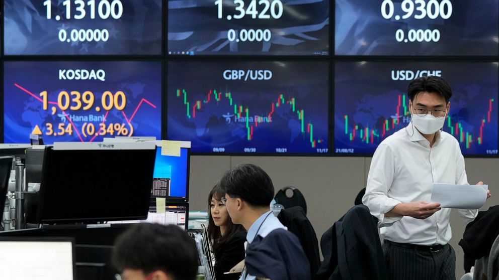 A currency trader passes by the screens showing the foreign exchange rates at the foreign exchange dealing room of the KEB Hana Bank headquarters in Seoul, South Korea, Wednesday, Nov. 17, 2021. Asian shares slipped Wednesday despite a rally on Wall 