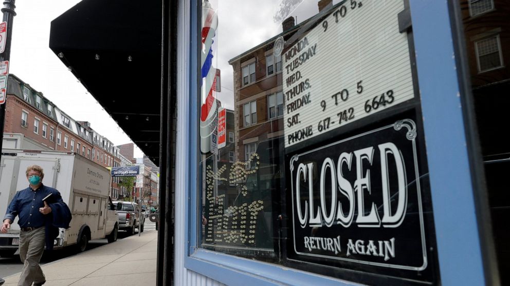 A pedestrian passes a closed barbershop during the coronavirus pandemic, Tuesday, May 12, 2020, in the North End neighborhood of Boston. (AP Photo/Steven Senne)