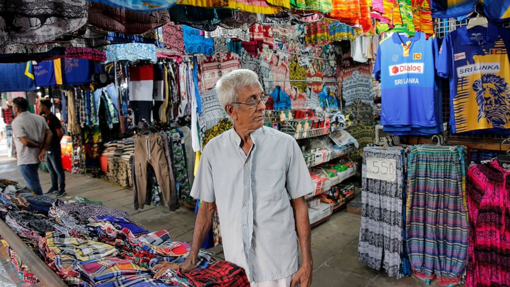 In this July 24, 2019, photo, Sri Lankan trader Ranepura Hewage Jayasena, 76, waits for customers at shop selling mementos in Colombo, Sri Lanka. Shocks from deadly suicide bombings on Easter Day in Sri Lanka are still reverberating throughout its ec