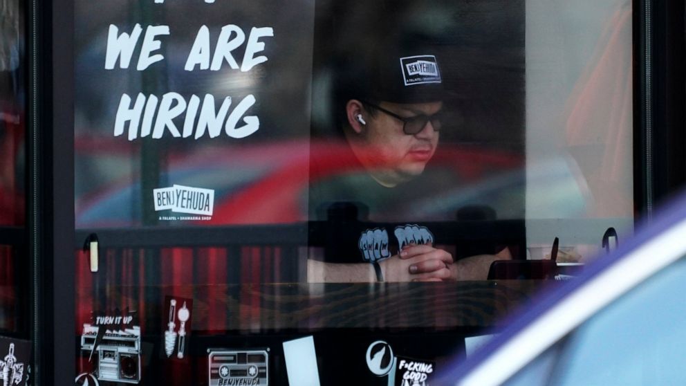 FILE - A hiring sign is displayed at a restaurant in Schaumburg, Ill., Friday, April 1, 2022. More Americans applied for jobless benefits last week, reported Thursday, Aug. 4, 2022, as the number of unemployed continues to rise modestly, though the l