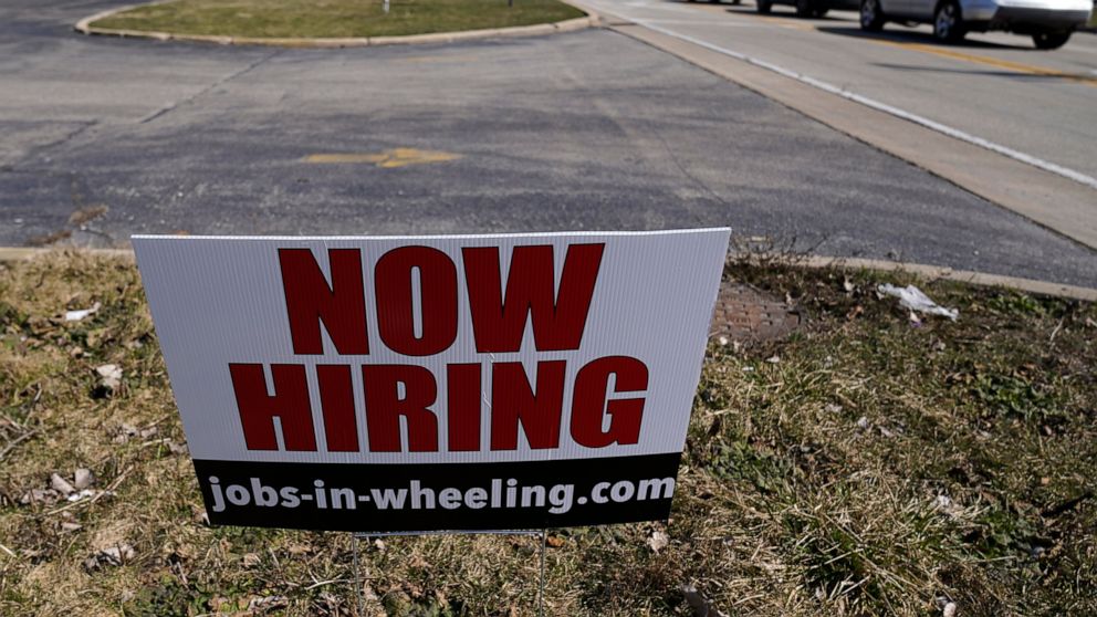 A hiring sign shows in Wheeling, Ill., Sunday, March 21, 2021. The number of Americans applying for unemployment aid fell last week to 547,000, a new low since the pandemic struck and a further encouraging sign that layoffs are slowing on the strengt