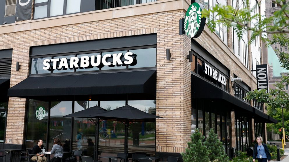 In this July 10, 2019, photo customers visit at a Starbucks in Minneapolis. Starbucks Corp. reports financial earnings on Thursday, July 25, 2019. (AP Photo/Jim Mone)