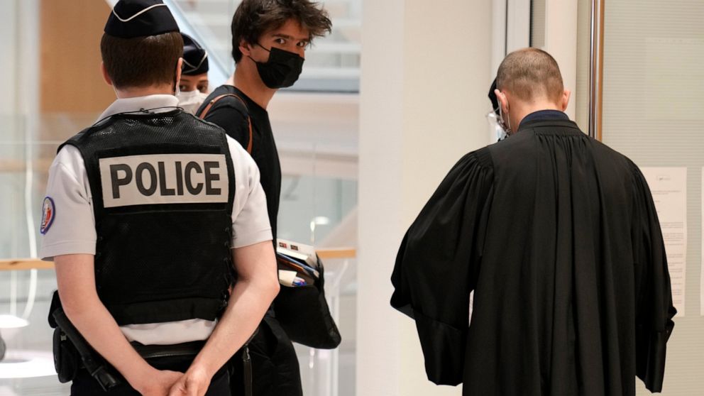 Juan Branco, a defendant lawyer, center with a black mask, arrives at the courtroom Thursday, June 3, 2021 in Paris. Thirteen people went on trial Thursday in Paris accused of cyberbullying or death threats against a teenage girl who posted comments 