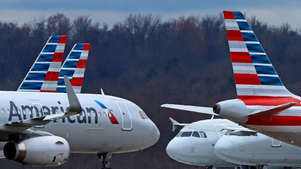 FILE - In this March 31, 2020 file photo American Airlines planes are parked at Pittsburgh International Airport in Imperial, Pa. There will be no more attempt at social distancing on American Airlines flights. The airline said Friday, June 26, that 