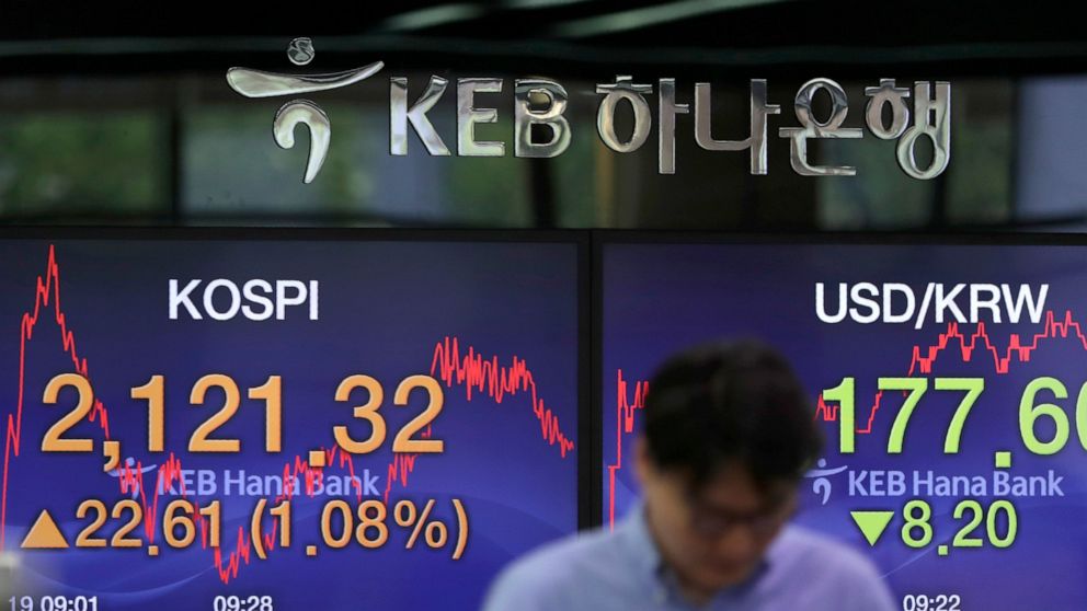 A currency trader talks near the screens showing the Korea Composite Stock Price Index (KOSPI), left, and the foreign exchange rate between U.S. dollar and South Korean won at the foreign exchange dealing room in Seoul, South Korea, Wednesday, June 1