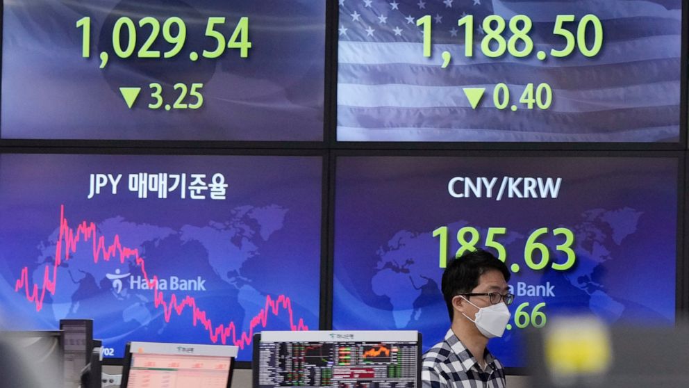 A currency trader passes by the screens showing the foreign exchange rates at the foreign exchange dealing room of the KEB Hana Bank headquarters in Seoul, South Korea, Thursday, Nov. 25, 2021. Asian stock markets fell Thursday after Federal Reserve 