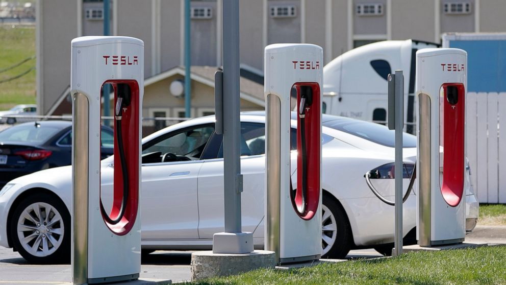 FILE - In this Monday, April 5, 2021 file photo, a Tesla electric vehicle charges at a station in Topeka, Kan. With strong sales of its electric cars and SUVs, Tesla on Monday, April 26, 2021 posted its seventh-straight profitable quarter. (AP Photo/