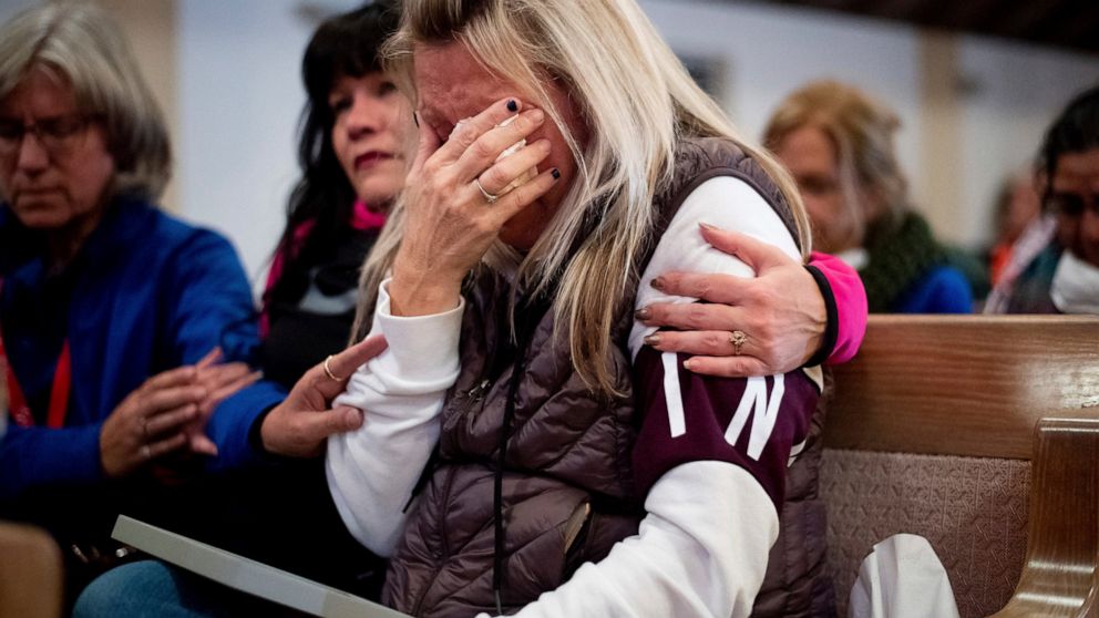 FILE - In this Nov. 18, 2018, file photo, Laura Martin mourns her father, TK Huff, who died during the Camp Fire, during a vigil in Chico, Calif. A scathing grand jury indictment unsealed Tuesday, June 16, 2020, into a Northern California wildfire th