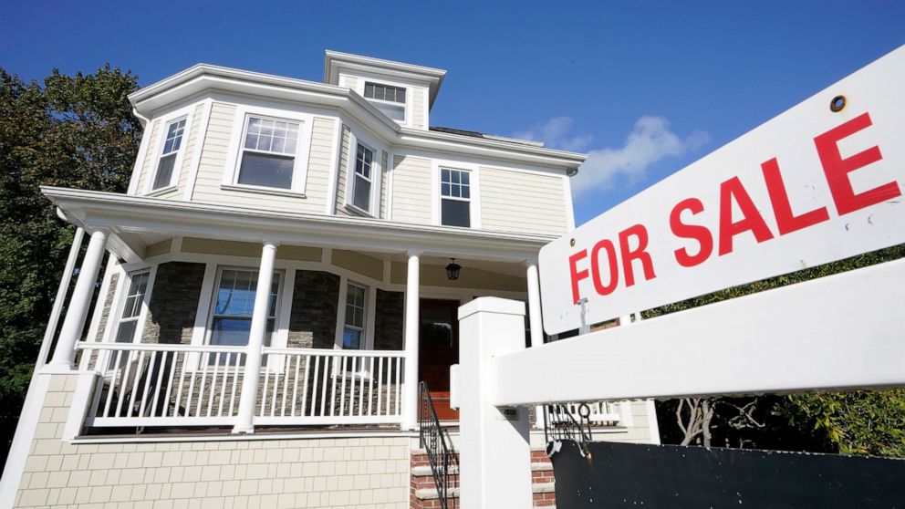 FILE - In this Tuesday, Oct. 6, 2020 file photo, a for sale sign stands in front of a house in Westwood, Mass. Mortgage rates were mixed this week and barely changed after rising for the first time last week following six weeks of declines. Average r