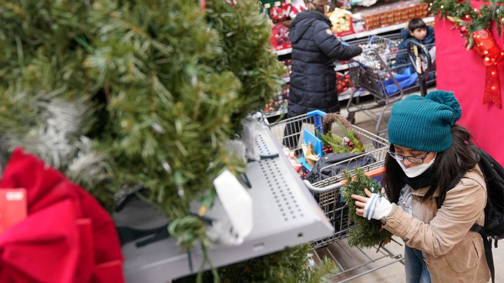 FILE - Andrea Mena shops in the holiday section of a Walmart in Secaucus, N.J., Tuesday, Nov. 22, 2022. The holidays are supposed to be a joyful time, but they can also be financially stressful. With gifts, social gatherings and plane tickets home, t