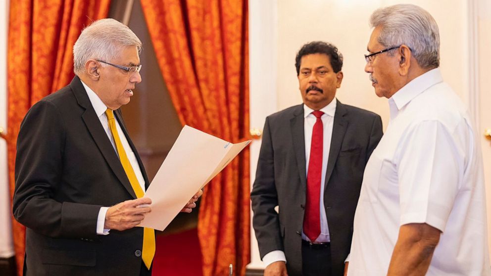 In this handout photograph provided by the Sri Lankan President's Office, President Gotabaya Rajapaksa, right, watches Ranil Wickremesinghe take the oath of office as the new prime minister in Colombo, Sri Lanka, Thursday, May 12, 2022. Wickremesingh