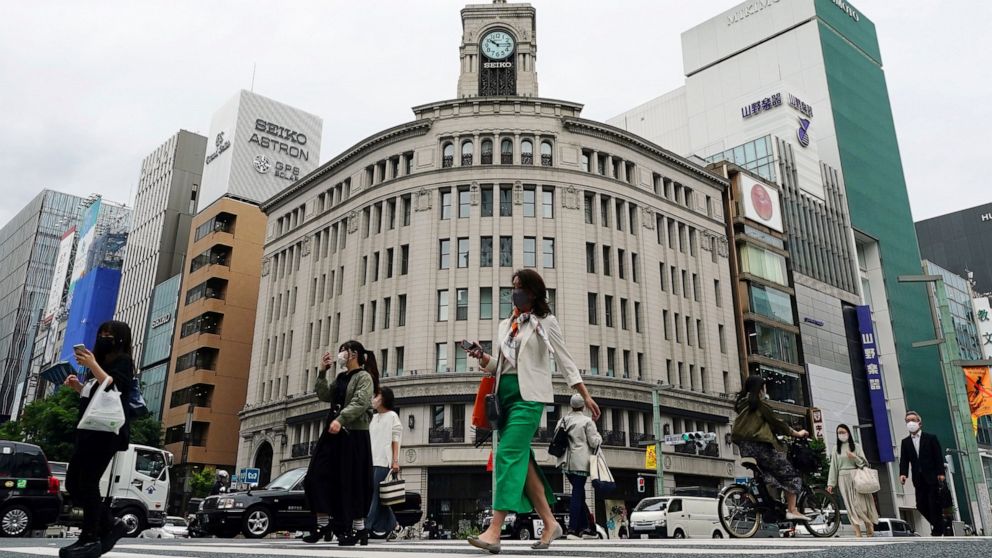 FILE - In this May 11, 2021, file photo, people wearing protective masks to help curb the spread of the coronavirus walk at Ginza shopping district, in Tokyo. Japan’s economy grew at an annual rate of 1.3% in the last quarter, raising hopes for a gra