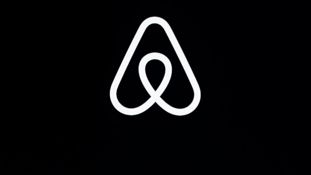 FILE - This Feb. 22, 2018, file photo shows an Airbnb logo during an event in San Francisco. Home-sharing site Airbnb posted a $3.9 billion loss in the fourth quarter of 2020 as it suffered from the pandemic downturn in travel and recorded one-time c
