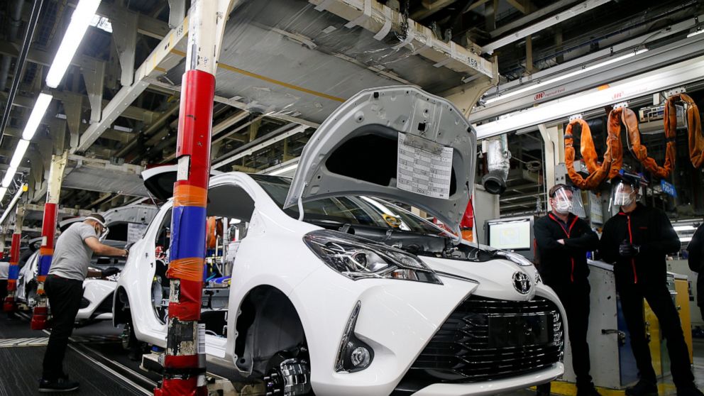 FILE - In this April 28, 2020, file photo, an employee wearing a face mask works on a Yaris car at the Toyota car factory in Onnaing, northern France. Toyota announced Thursday, Aug. 19, 2021, is scaling back 40% of its production, affecting 14 auto 