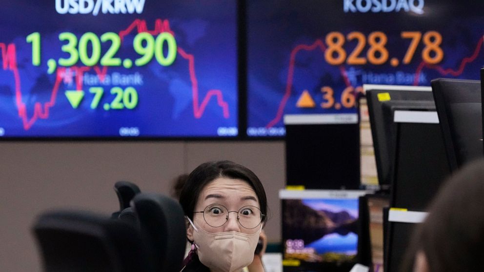 A currency trader talks with her colleague at the foreign exchange dealing room of the KEB Hana Bank headquarters in Seoul, South Korea, Friday, Aug. 5, 2022. Asian stock markets rose Friday ahead of U.S. job market data that might influence Federal 