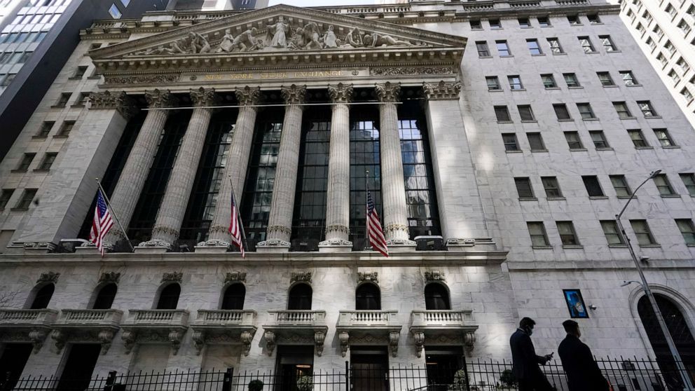 FILE - In this March 23, 2021 file photo, pedestrians walk past the New York Stock Exchange in New York's Financial District. Wall Street is gearing up for a blockbuster corporate earnings season, Thursday, July 8, as companies issue their results fo
