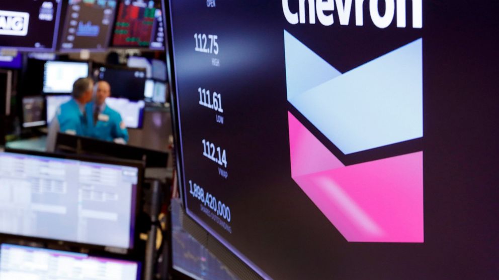 FILE - This Oct. 8, 2019, file photo shows the logo for Chevron on the floor of the New York Stock Exchange. Chevron Corp. reports financial results Friday, Nov. 1. Chevron said Tuesday, Dec. 10, it will book a charge of at least $10 billion because 