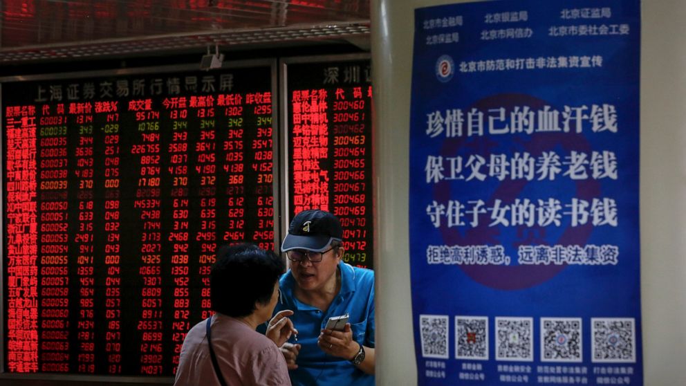 Chinese investors chat each other as they monitor stock prices at the brokerage house in Beijing, Thursday, June 27, 2019. Asian stocks advanced Thursday ahead of a meeting between U.S. President Donald Trump and Chinese leader Xi Jinping at the G-20