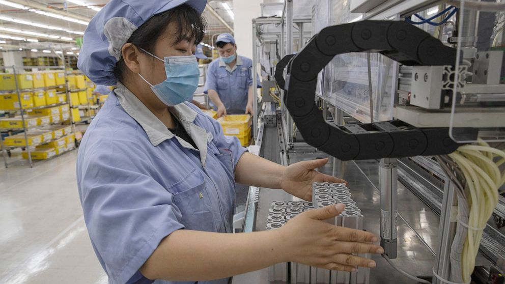 FILE - A worker at SMC, a Japanese pneumatic engineering company, assembles products at a factory in Beijing on Wednesday, May 13, 2020. China's manufacturing activity improved in June after anti-virus controls that shut down Shanghai and other indus