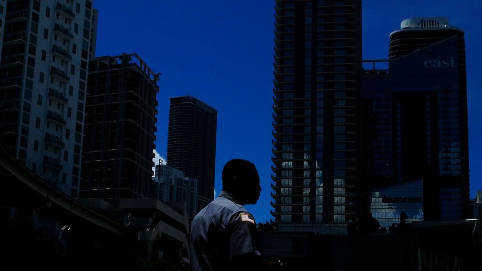 FILE- In this June 12, 2019, file photo a man walks in downtown Miami. Ten straight years of growth. Unemployment at a five-decade low. Higher wages for the poorest workers. The economic expansion that just became America’s longest on record didn’t p