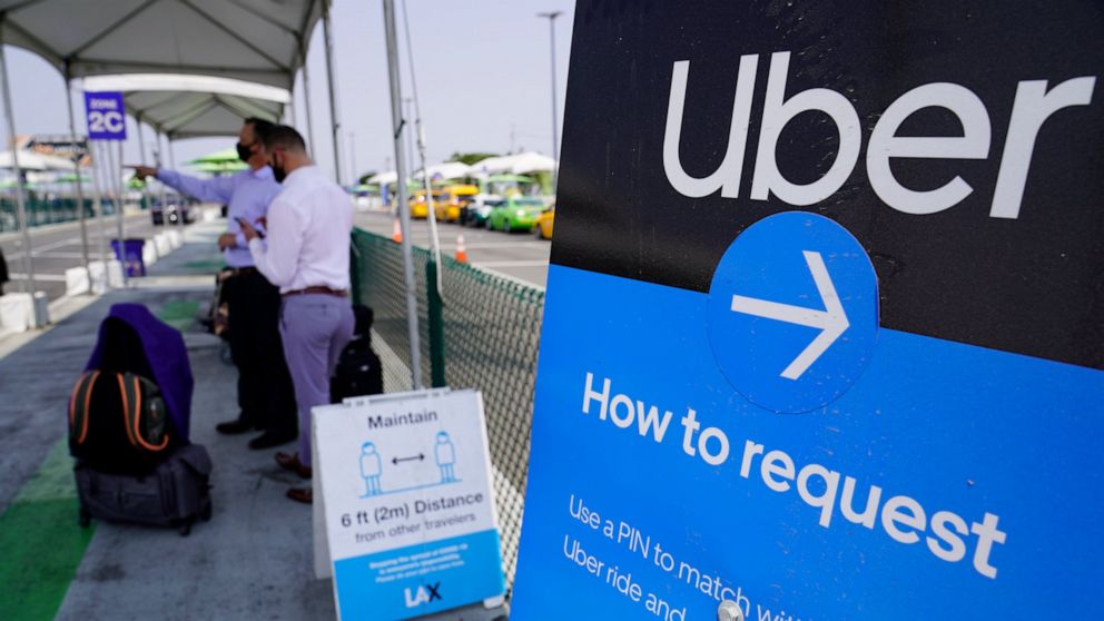 FILE - In this Aug. 20, 2020, file photo travellers request an Uber ride at Los Angeles International Airport, USA. The San Francisco-based ride hailing giant Uber said Thursday April 29, 2021, it aims to recruit 20,000 more drivers in the U.K. to he