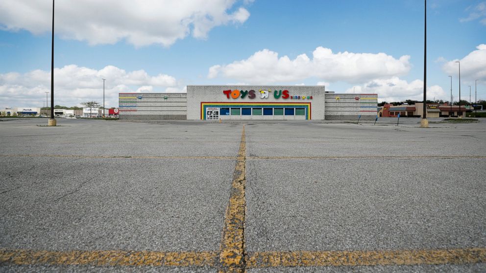 A closed Toys R Us building sits in front of an empty parking lot, Wednesday, May 6, 2020, in Des Moines, Iowa. Nearly 3.2 million laid-off workers applied for unemployment benefits last week as the business shutdowns caused by the viral outbreak dee