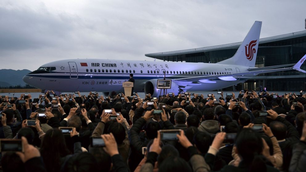 In this Dec. 15, 2018, photo, invited guests take photos of the Boeing 737 Max 8 airplane deliver to Air China during a ceremony at Boeing Zhoushan 737 Completion and Delivery Center in Zhoushan, east China's Zhejiang Province. Air China, one of Chin