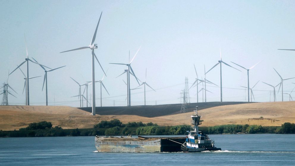 FILE - A tugboat pushes a barge down the Sacramento River past wind turbines near Rio Vista, Calif., on Monday, Sept. 23, 2013. The Biden administration announced, Thursday, May 26, 2022, that it's opening a proposed notice of sale for five leases of