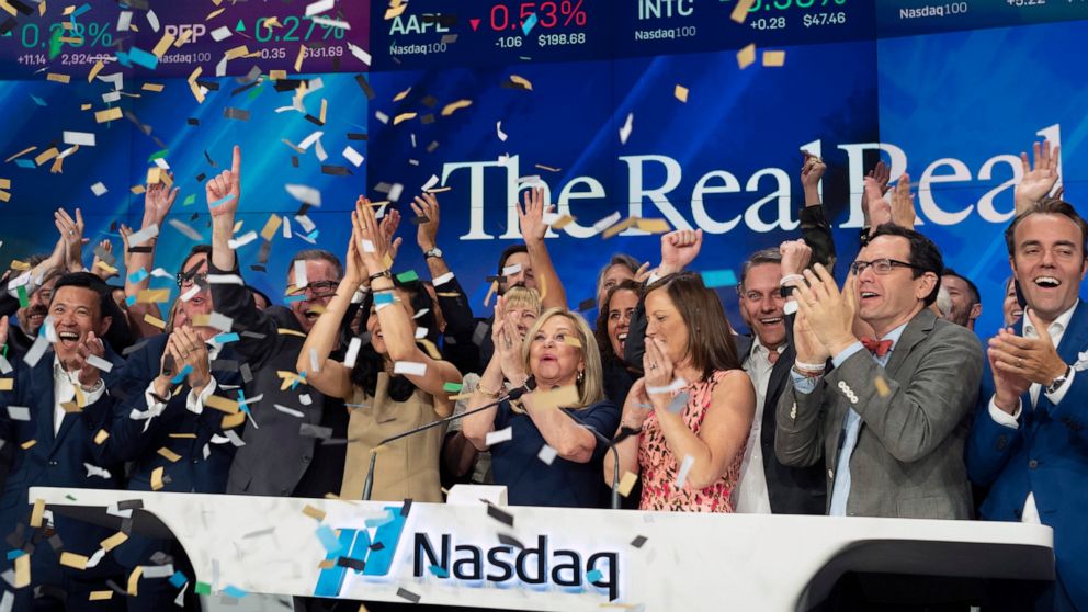 Julie Wainwright, center, CEO of The RealReal, celebrates her company's IPO at the Nasdaq opening bell, Friday, June 28, 2019 in New York. The online reseller of luxury brand clothing and accessories is based in San Francisco. (AP Photo/Mark Lennihan)