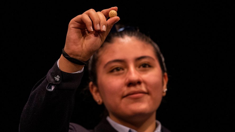 a student from Madrid's San Ildefonso school shows the winning Christmas lottery number 86148 at Madrid's Teatro Real opera house during Spain's bumper Christmas lottery draw known as El Gordo, or The Fat One, in Madrid, Spain, Wednesday, Dec. 22, 20