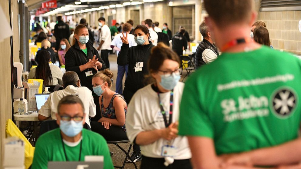 People queue up to receive a coronavirus vaccination at a surge vaccine operation set up at Twickenham rugby stadium, south-west London, Monday May 31, 2021. Up to 15,000 doses of vaccine are ready to be administered at the walk-in centre which has b